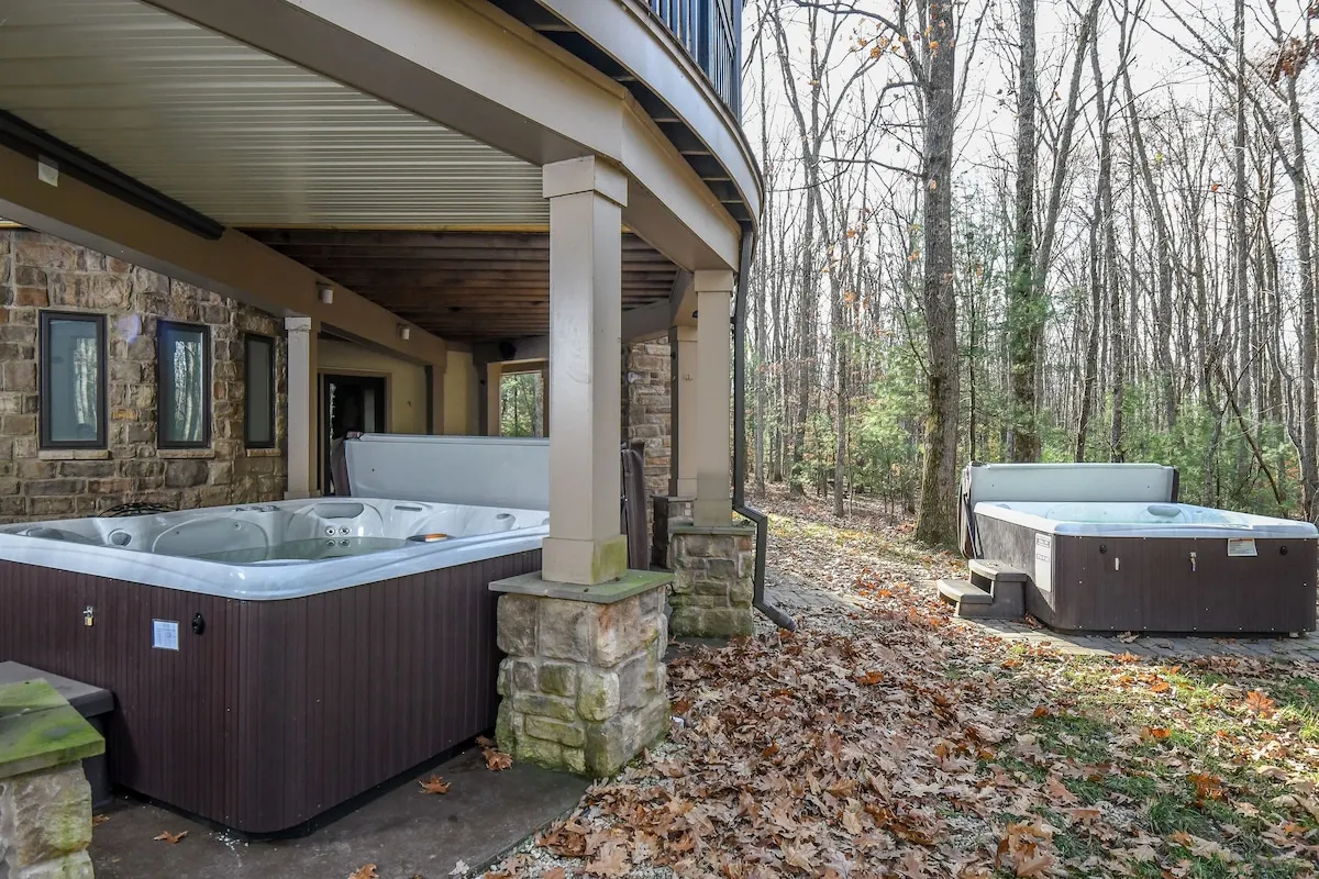 Both outdoor hot tubs beside the stone patio