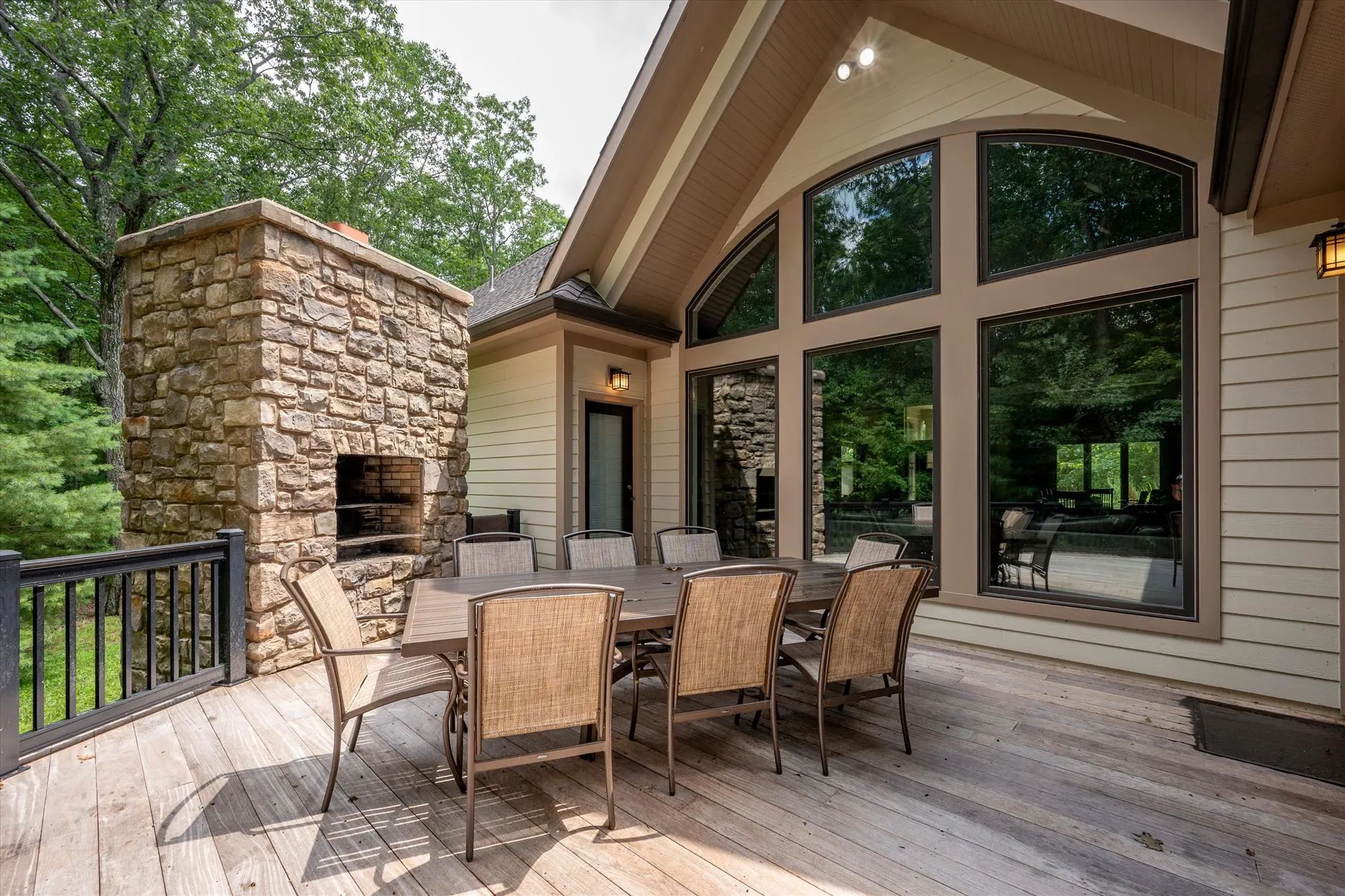 Wraparound deck with railing and panoramic forest views at Woodland Chalet