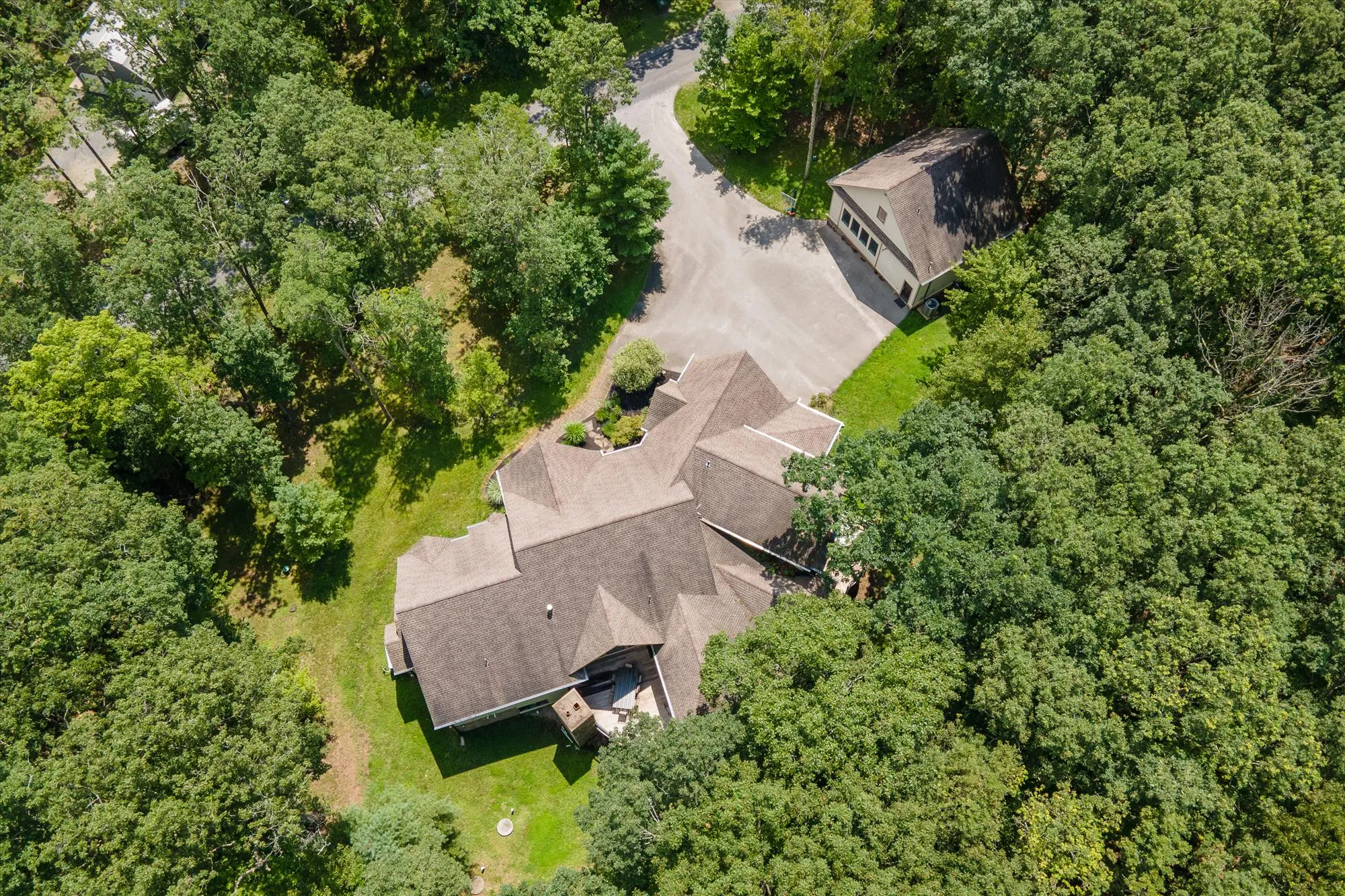 Aerial drone view of Woodland Chalet surrounded by forest near Deep Creek Lake