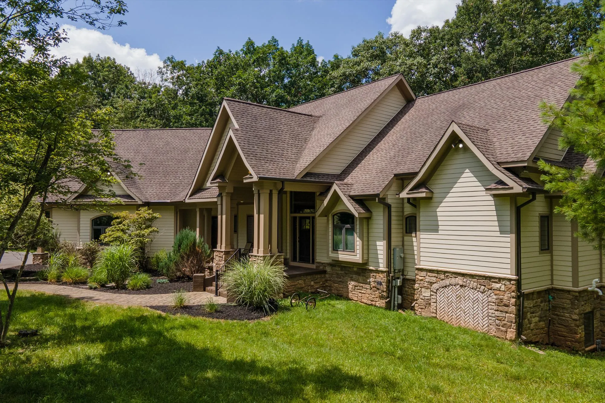 Full exterior view of the three-level Woodland Chalet in wooded mountain setting