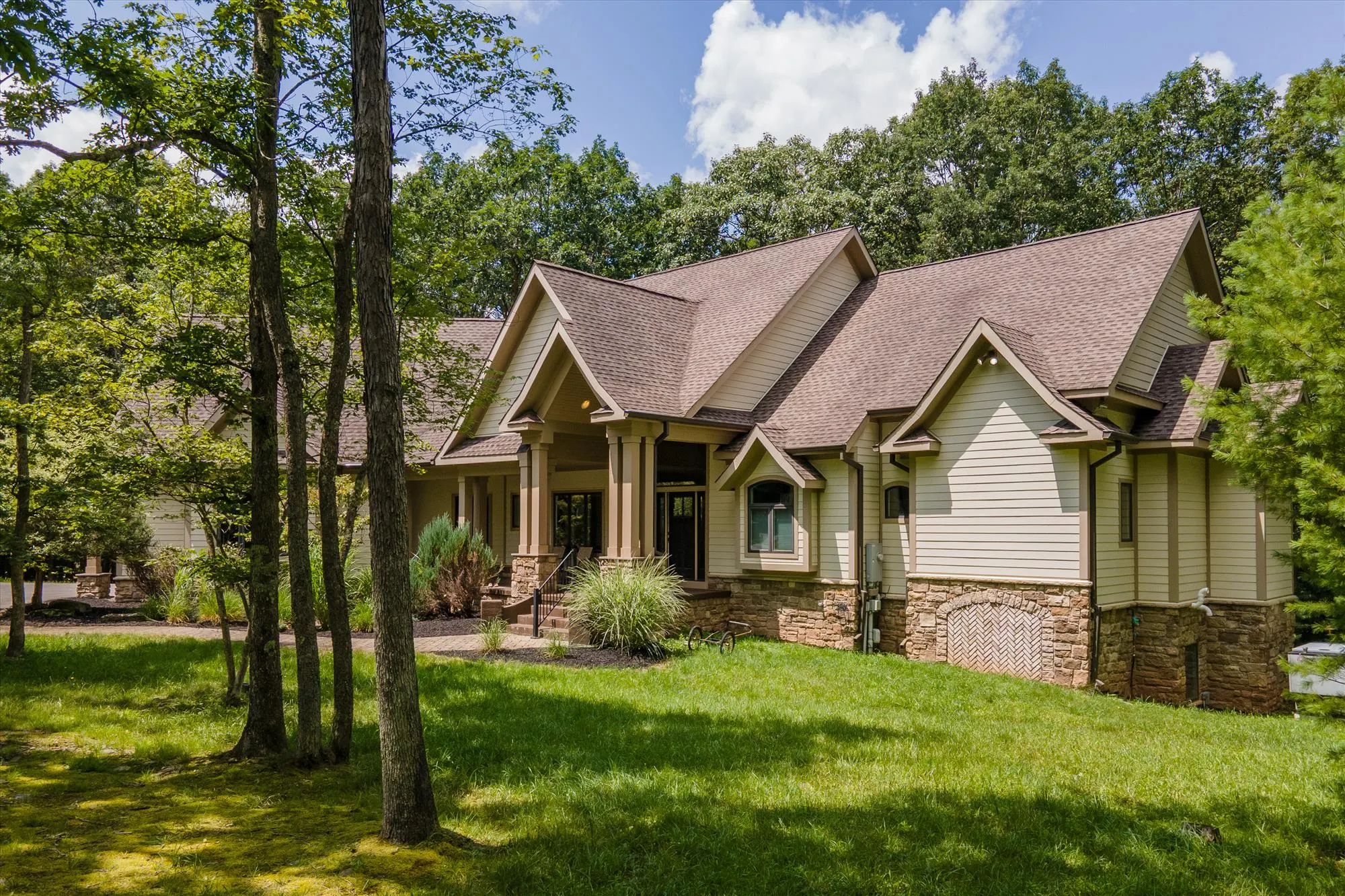 Side view of Woodland Chalet showcasing expansive multi-level deck and wooded surroundings