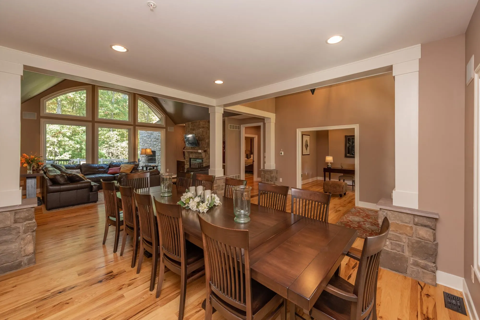 Elegant dining area with chandelier and views of the surrounding forest