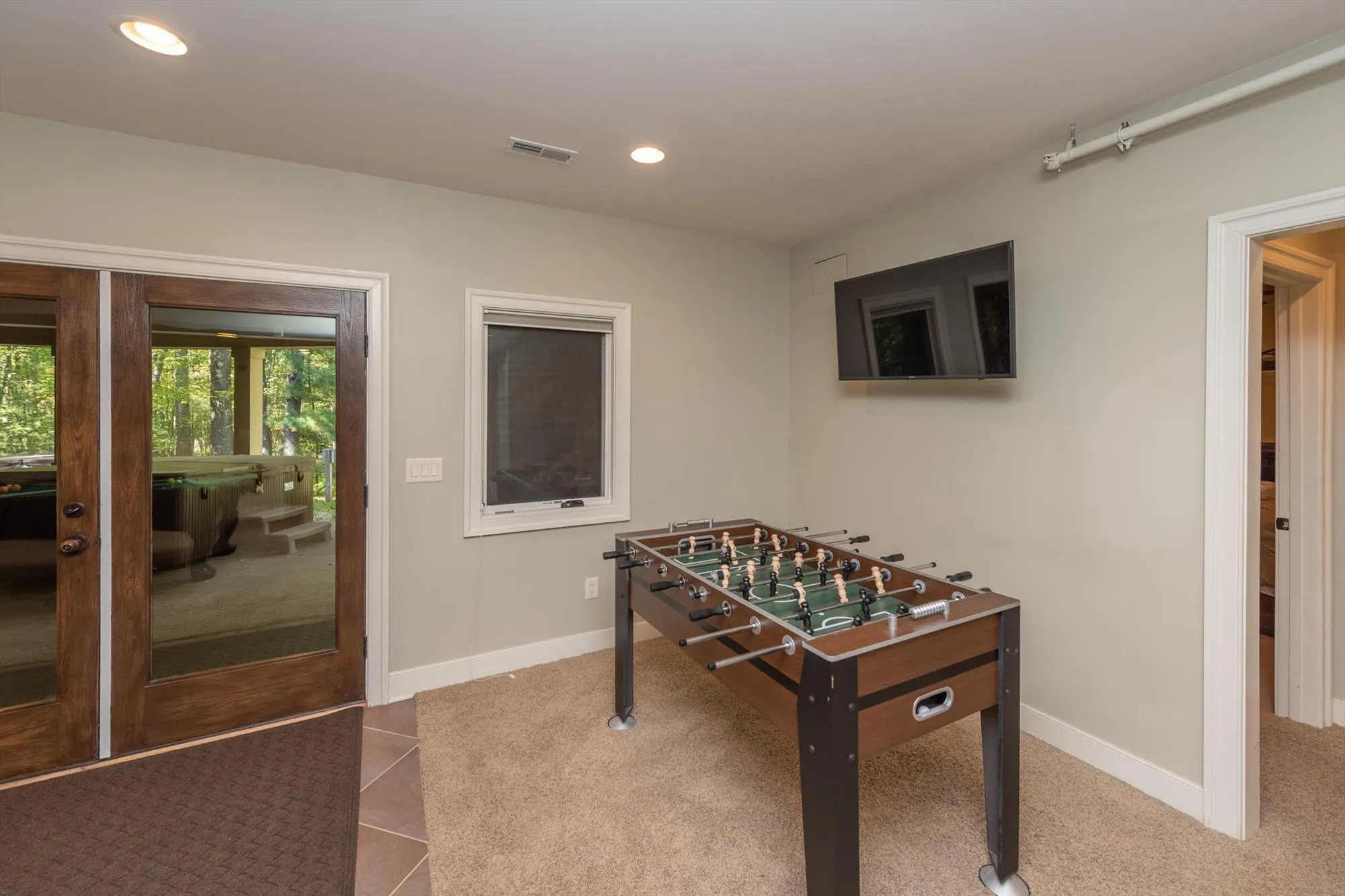Expansive game room with pool table and foosball table at Woodland Chalet
