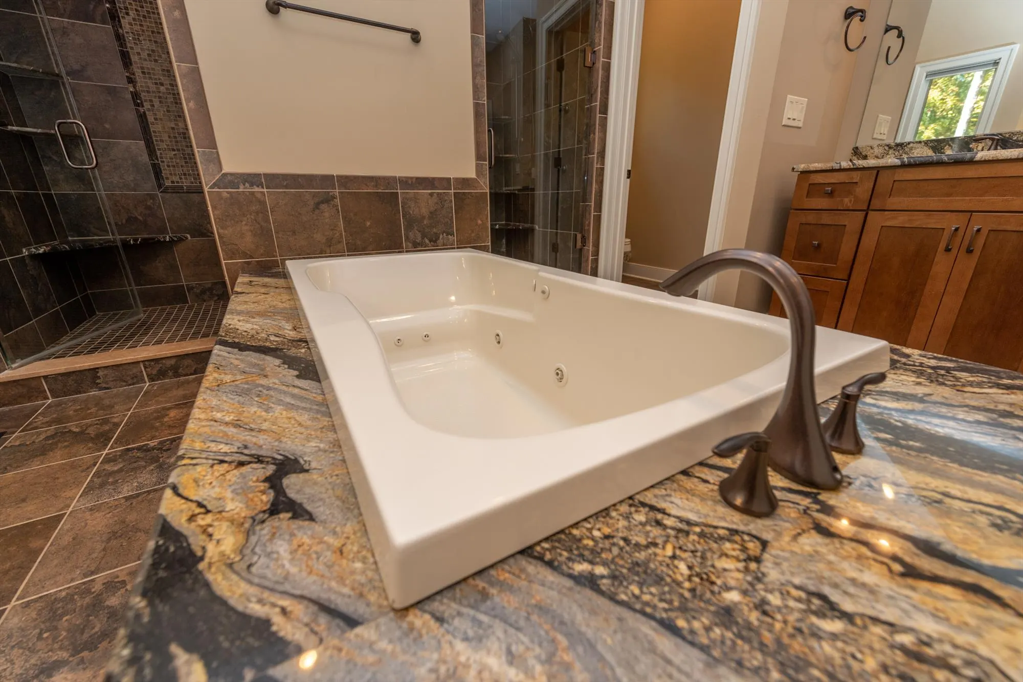 Oversized jetted soaking tub in the primary suite bathroom for relaxation